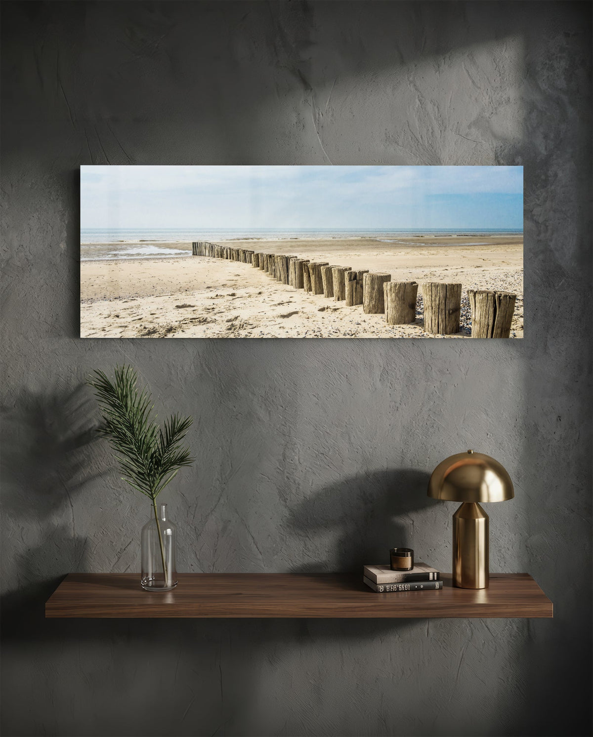 Weathered wood posts on the beach glass wall art above a floating walnut shelf with a brass lamp