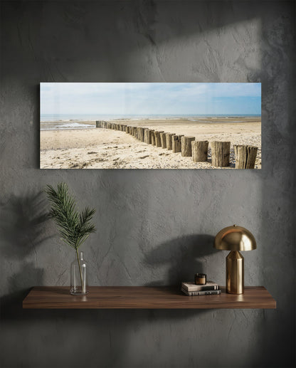 Weathered wood posts on the beach glass wall art above a floating walnut shelf with a brass lamp