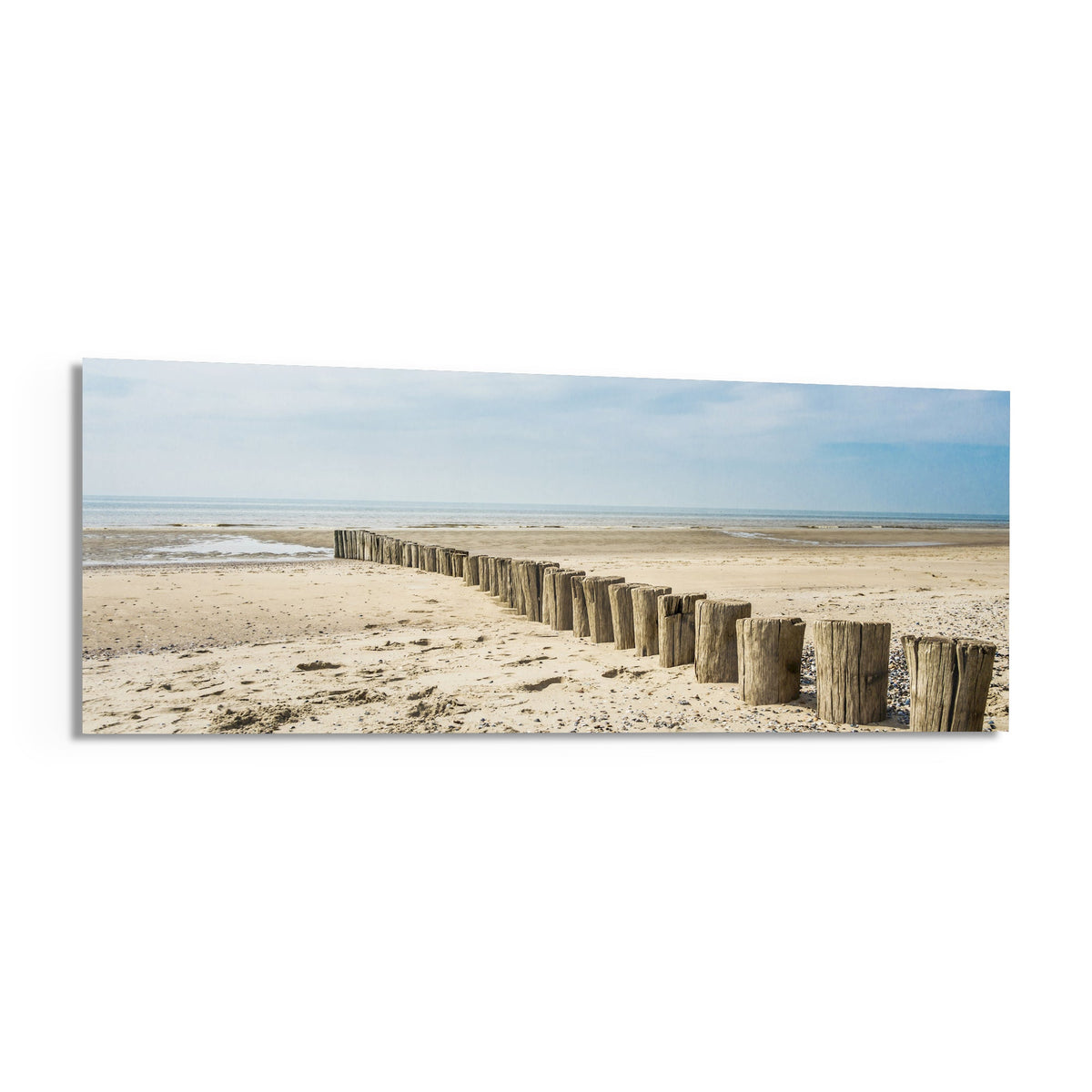 Weathered wood posts on the beach panoramic glass print angled on a white background