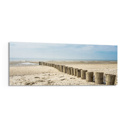 Weathered wood posts on the beach panoramic glass print angled on a white background