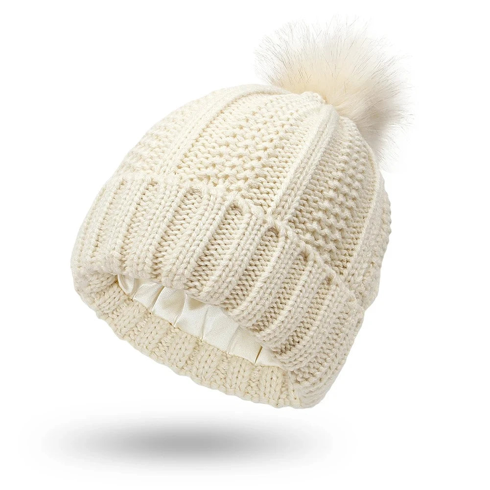 Beige cable knit beanie with silk satin interior lining protects hair from frizz
