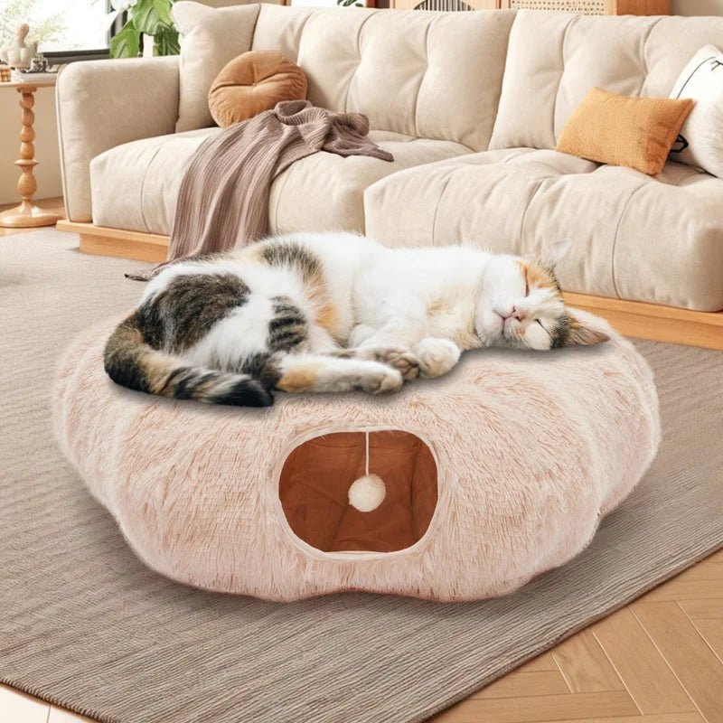 Beige plush cat tunnel bed with sleeping cat on top and peekaboo entrance below