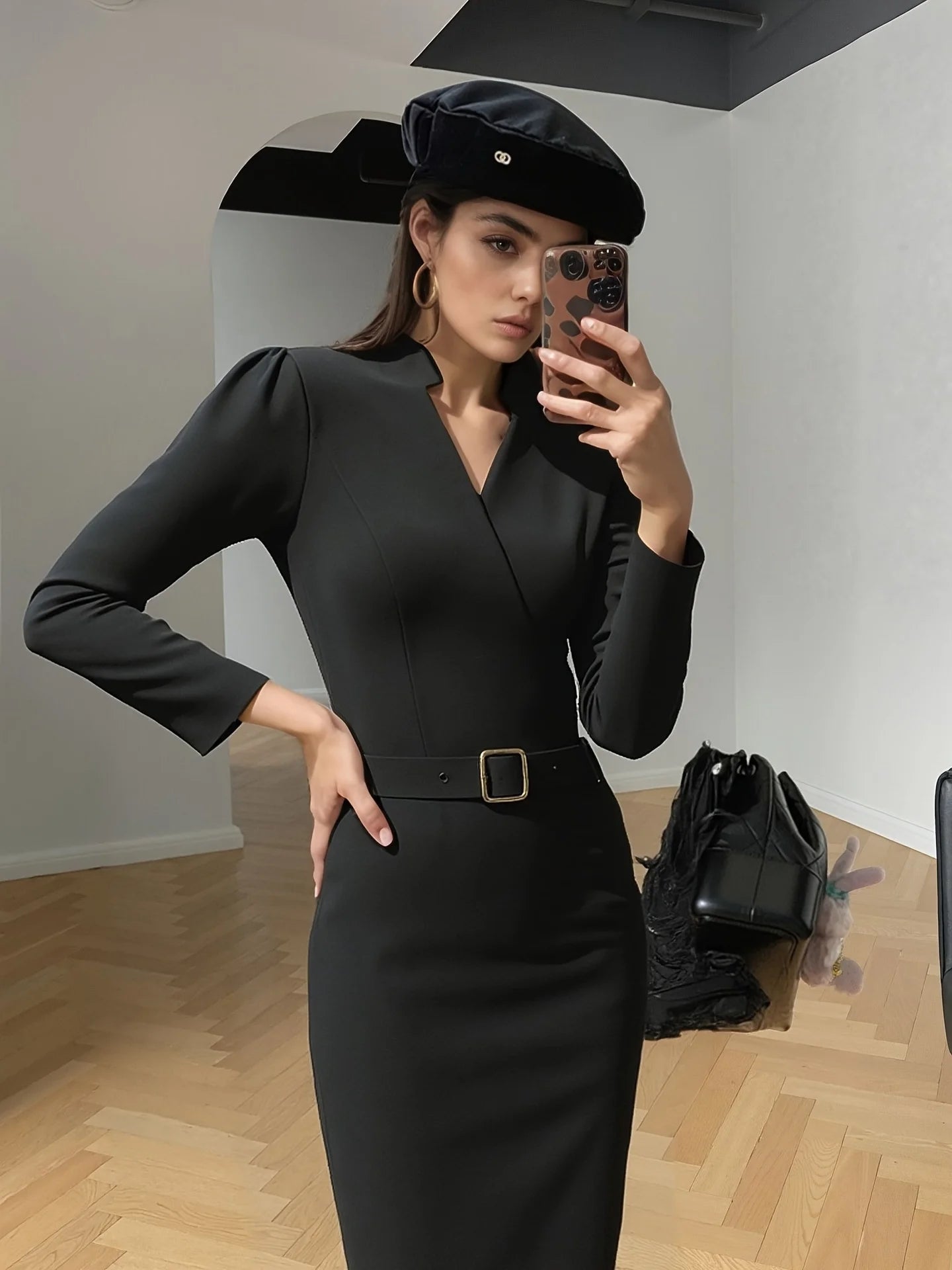 Black belted midi dress captured indoors with a chic minimalist look