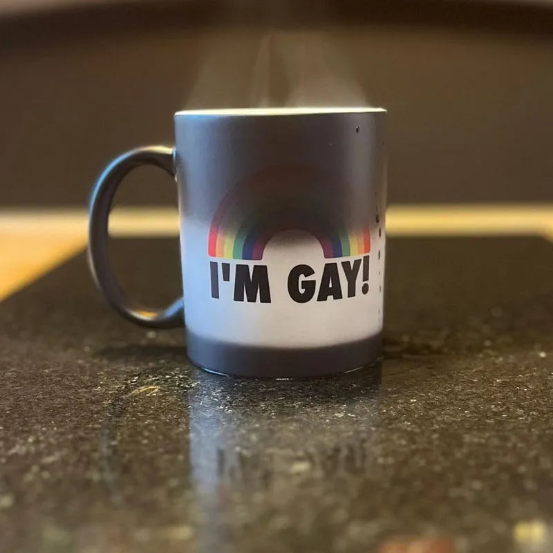 Black heat-sensitive mug revealing rainbow “I’M GAY!” design when hot