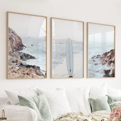 Surf wall art set of 3 with surfboard, blue ocean beach, and coastal rocks
