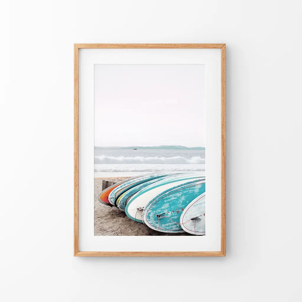 Colorful surfboards wall art print lined up on an ocean beach