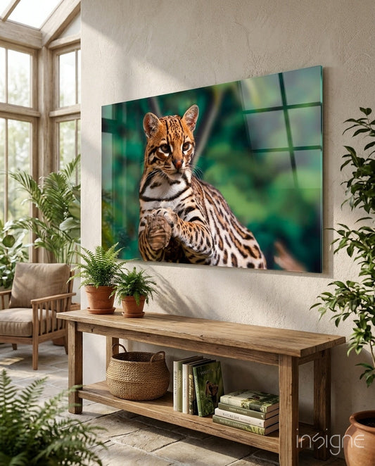 Spotted wild cat glass wall art with golden eyes on emerald jungle blur