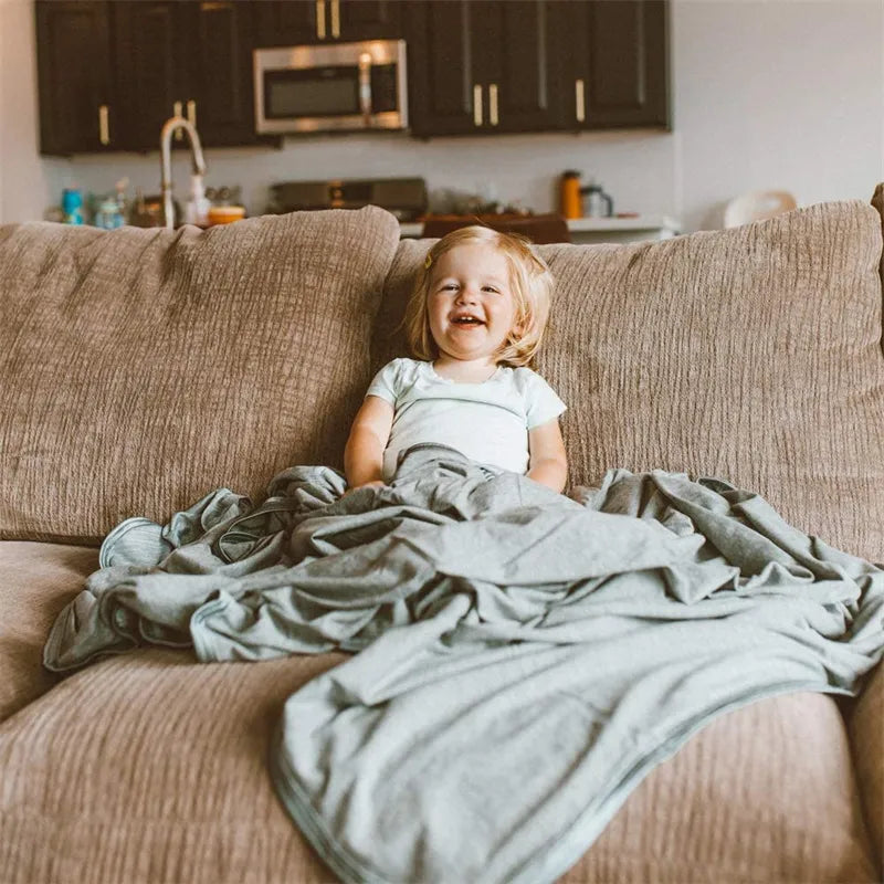 Child relaxing on couch covered with breathable cooling throw blanket