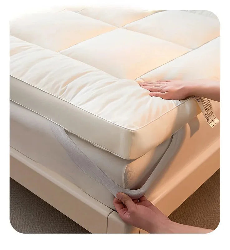Close-up of white quilted mattress topper pad showing thick padded edges