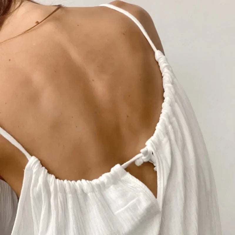 Close-up of white spaghetti strap halter nightgown showing adjustable straps and open back design detail