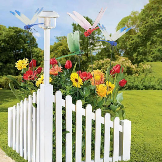 Colorful dragonfly garden decoration clips placed among flowers in garden bed