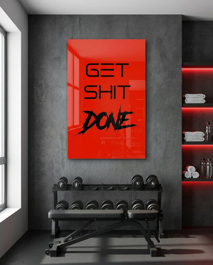 Get Sh*t Done black brush script on red glass wall art in a home gym above a dumbbell rack