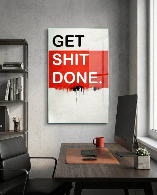 Red Band Drip Get Sh*t Done glass wall art in a gray home office above a desk with a monitor and a black chair
