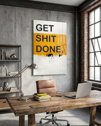 Orange Band Drip Get Sh*t Done glass wall art above a rustic desk in an industrial office by a brick wall