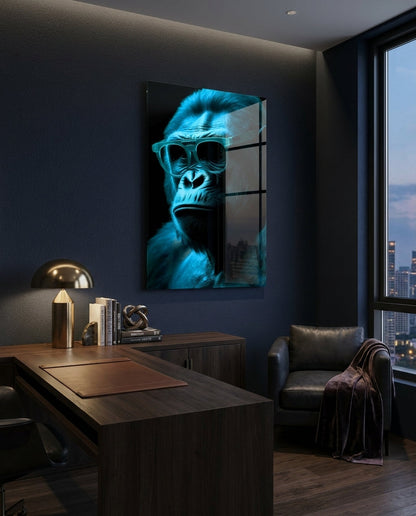 Blue thinking gorilla in sunglasses glass wall art in a dark office above a wooden desk beside a city window