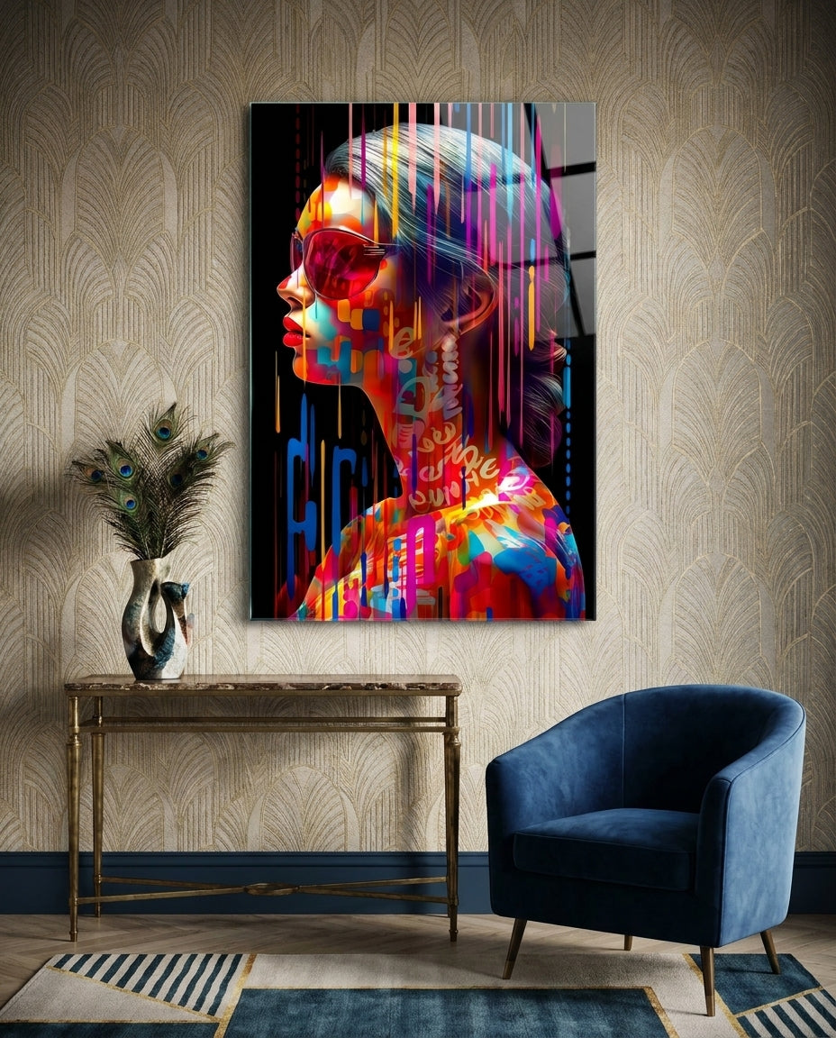 Rainbow drip woman in profile glass wall art above a wood console beside a blue velvet armchair