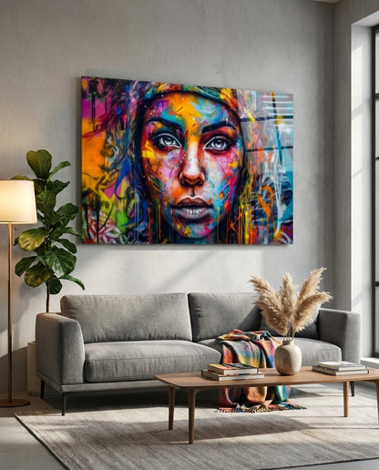Wide eyed woman graffiti glass wall art above a gray sofa in a bright living room