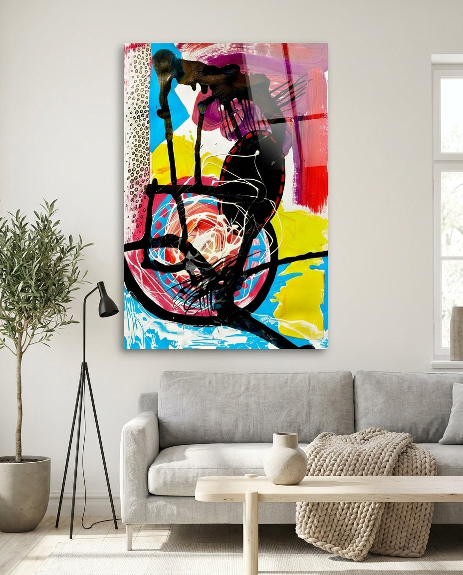 Black scribble and magenta abstract glass wall art above a gray sofa beside an olive tree and a black floor lamp