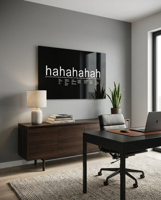 Black laughter scale typography glass wall art above a dark desk and office chair in a home office