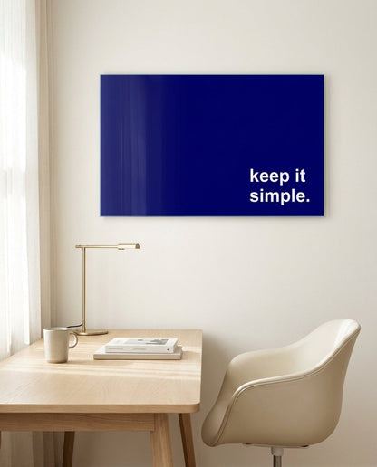 Keep it simple white text on navy glass wall art above a light wood desk and cream chair