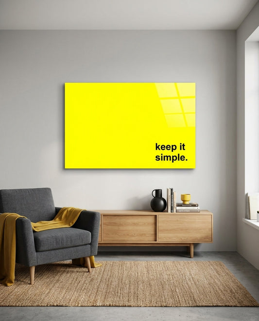 Keep it simple black text on yellow glass wall art above a wood sideboard and gray armchair