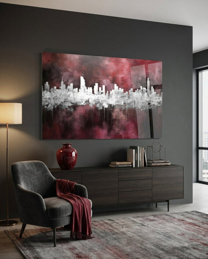 Burgundy abstract skyline glass wall art above a dark sideboard beside a gray armchair with a red throw