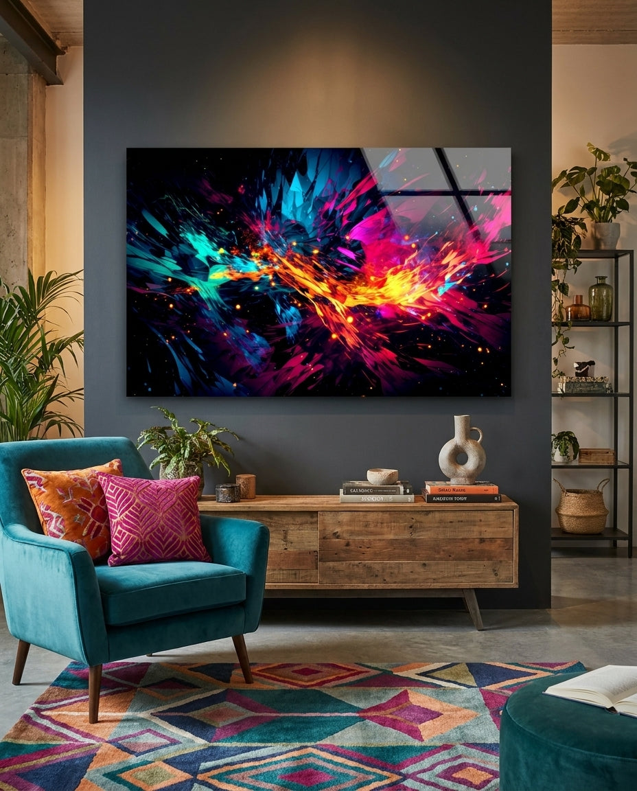 Magenta and cyan color splash abstract glass wall art on a dark wall above a wood sideboard beside a teal armchair