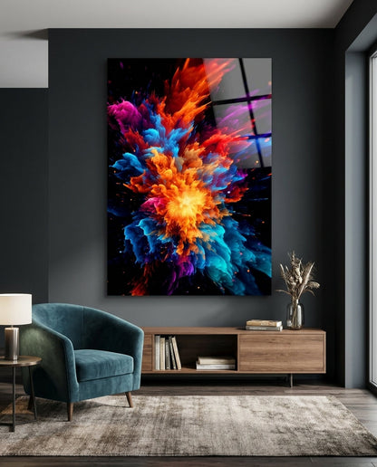 Fiery color burst abstract glass wall art on a dark gray wall above a low wooden sideboard beside a teal armchair