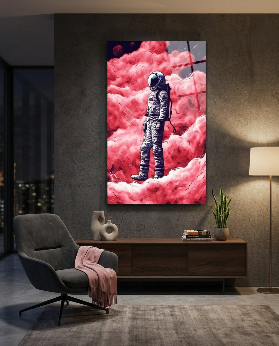 Astronaut in pink clouds glass wall art on a dark wall above a wooden sideboard beside a gray chair with a pink throw