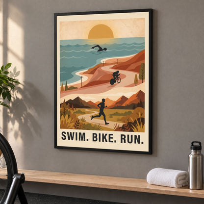 Framed swim bike run poster on the wall of a home training room, above a shelf with a towel and a bottle