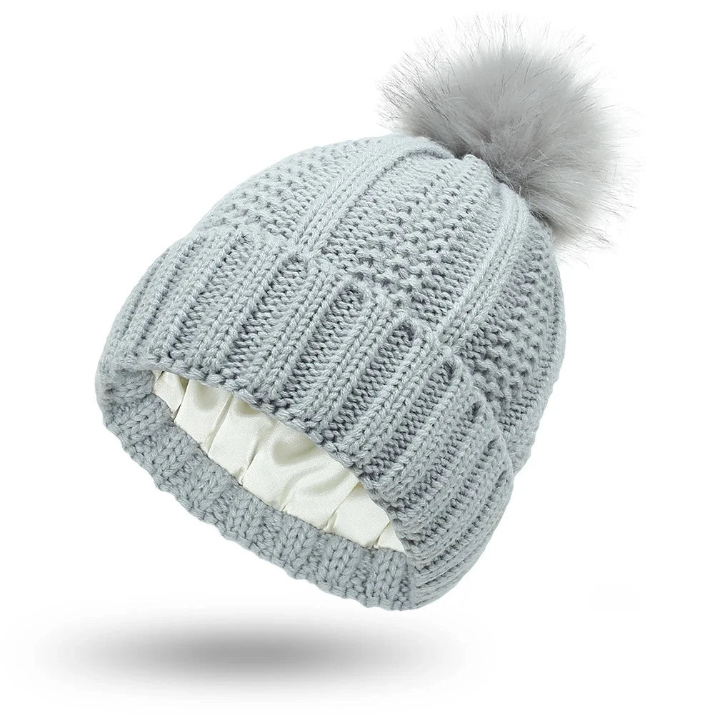 Gray cable knit beanie with silk satin interior lining protects hair from frizz
