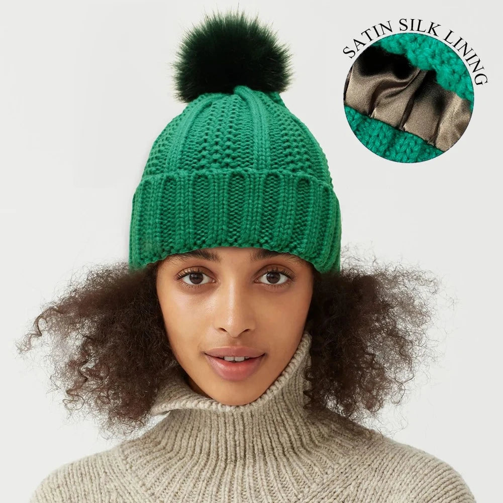 Green cable knit beanie with satin silk lining and faux fur pom pom for hair protection