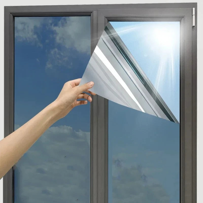 Hand applying privacy window film to glass demonstrating easy DIY installation squeegee technique