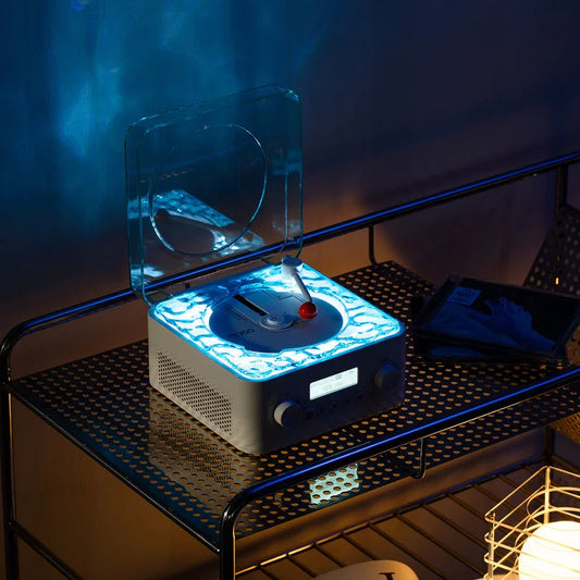 Illuminated retro CD player Bluetooth speaker with glowing blue water ripple effect display on gaming desk at night