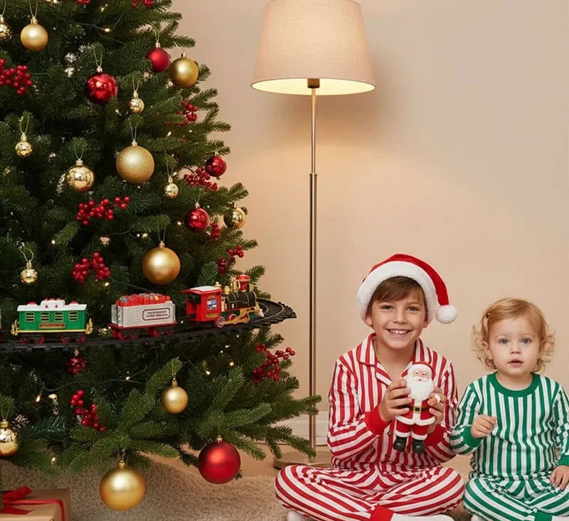 Kids watching electric Christmas train with lights circle around decorated holiday tree