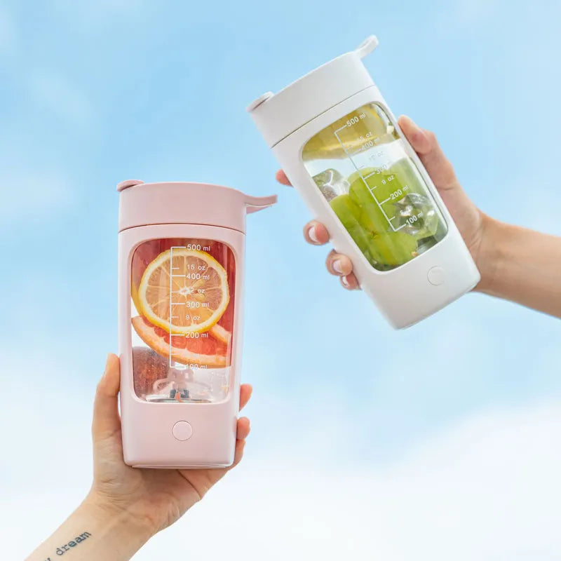 Light coffee and white automatic mixing fitness cups filled with fruit, handheld outdoor use