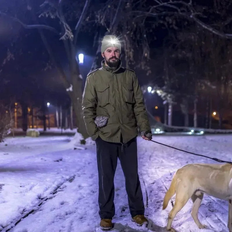 Man wearing bluetooth beanie with led light while walking dog at night