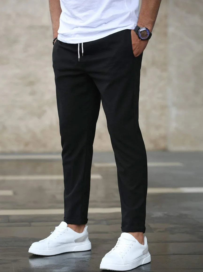 Men’s slim-fit stretch pants in Black shown on model, casual front view