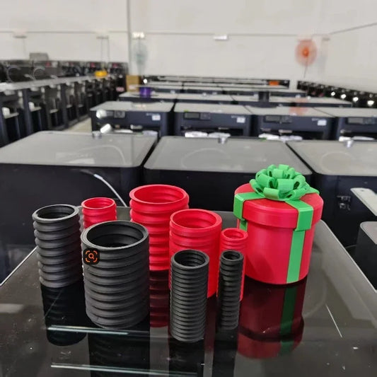 Multiple 3D printed Christmas gift boxes in red, black, and green - matryoshka nesting set display