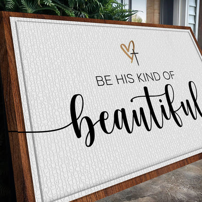 White canvas sign with a gold heart and cross and black script reading Be His Kind of Beautiful, seen at an angle