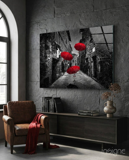 Red umbrellas glass wall art, red umbrellas floating over a grayscale European alley