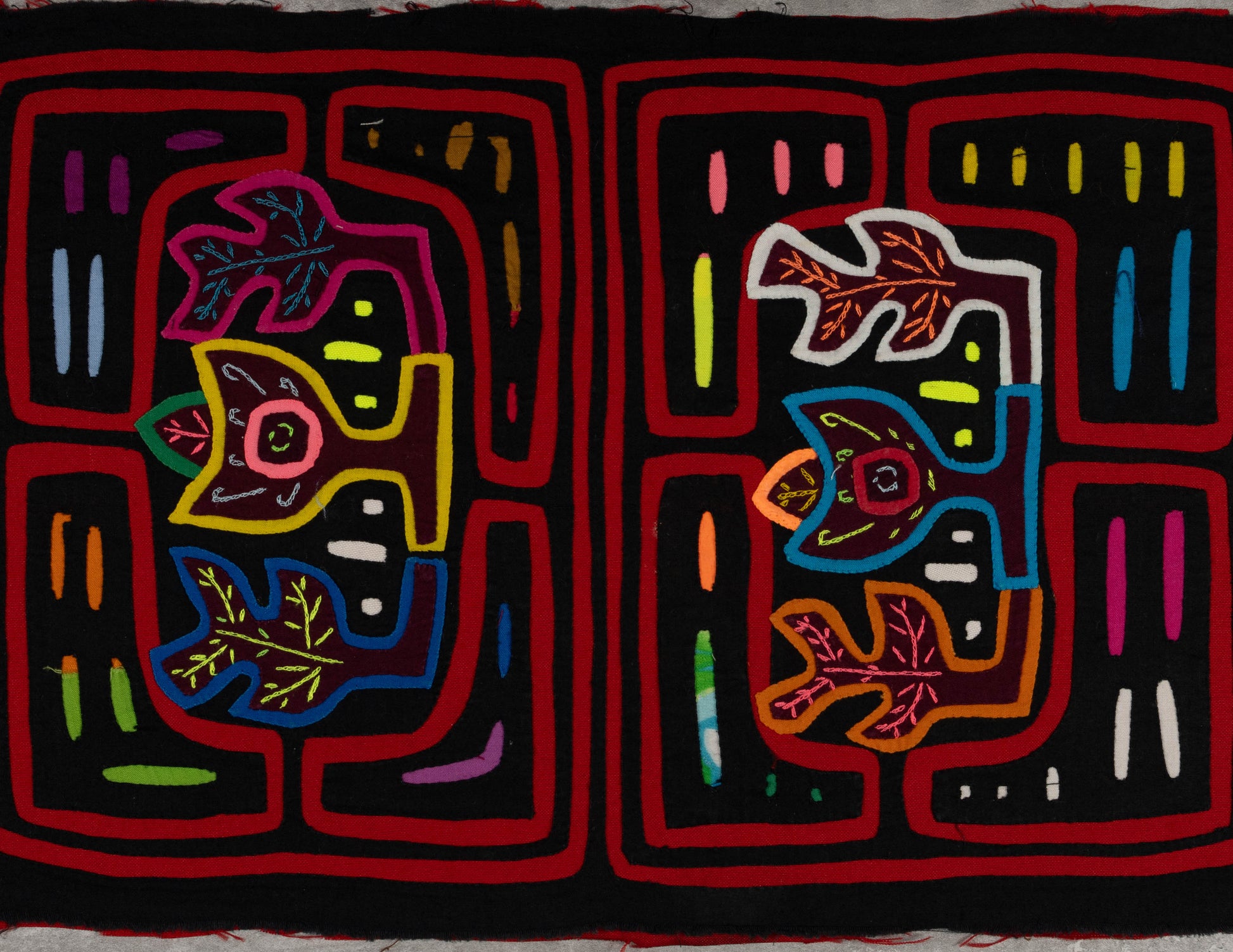 Hand-stitched Panama mola tapestry with a black and red floral motif, colorful folk-art fabric wall hanging