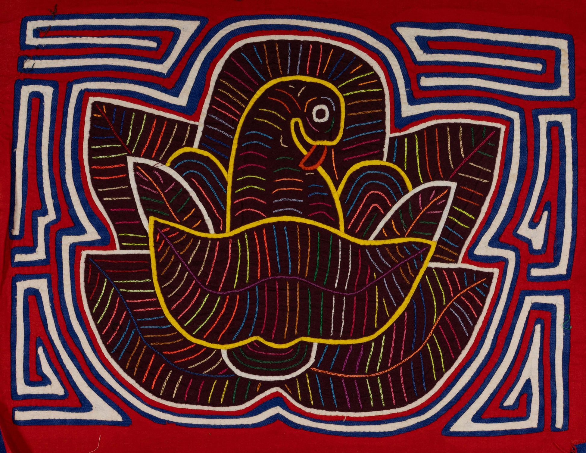 Hand-stitched Panama mola tapestry of a red, white and blue bird in a flower, colorful folk-art fabric wall hanging