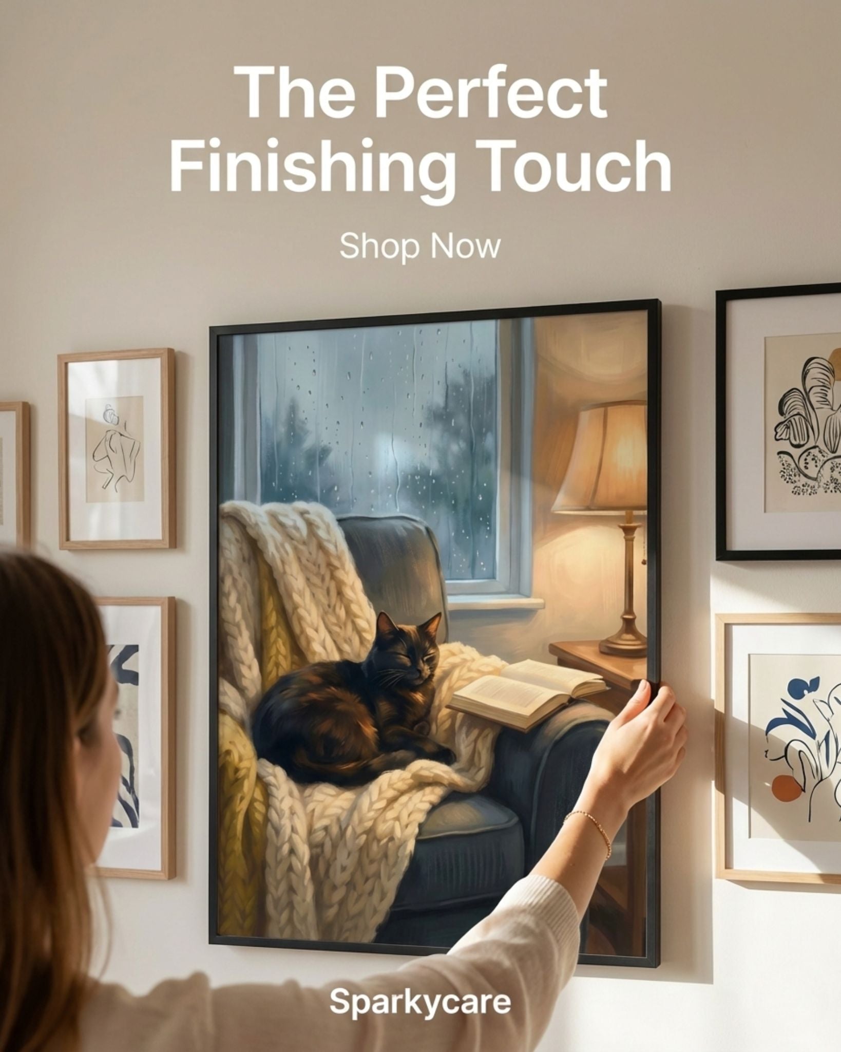 Person arranging framed pictures on a wall with text 'The Perfect Finishing Touch' and 'Shop Now' by Sparkycare.