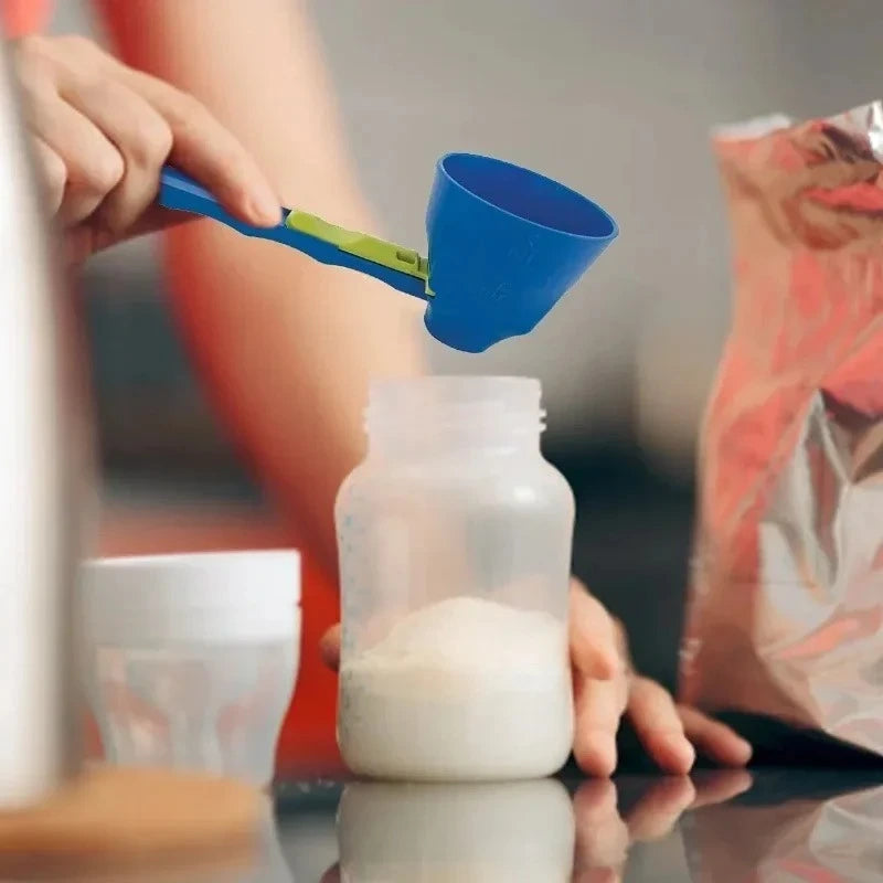 Person using a blue powder scoop to add white powder from a small container into a larger bottle.
