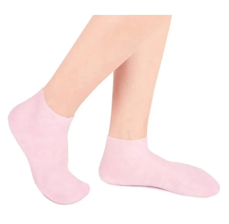 Person wearing pink gel moisturizing socks - comfortable indoor silicone booties for foot care