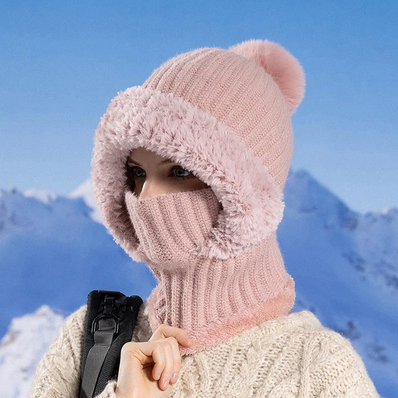 Pink knitted winter hat scarf mask worn outdoors in snowy mountains