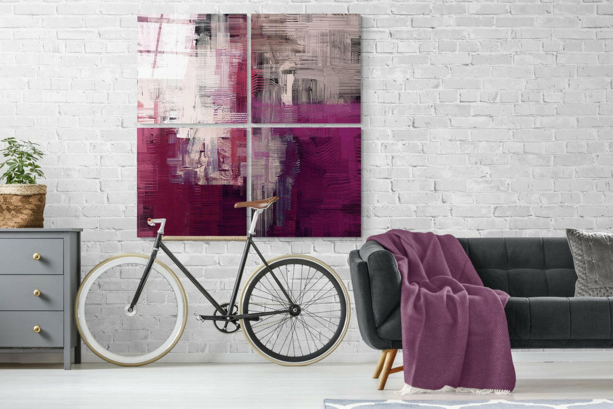 Magenta and blush abstract 4-panel glass wall art on a white brick wall above a green sofa and a bicycle