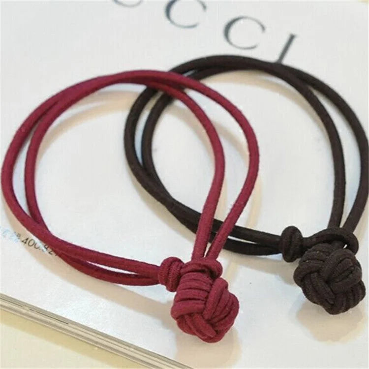Red and brown hair tie elastic bands close-up showing knot ball design
