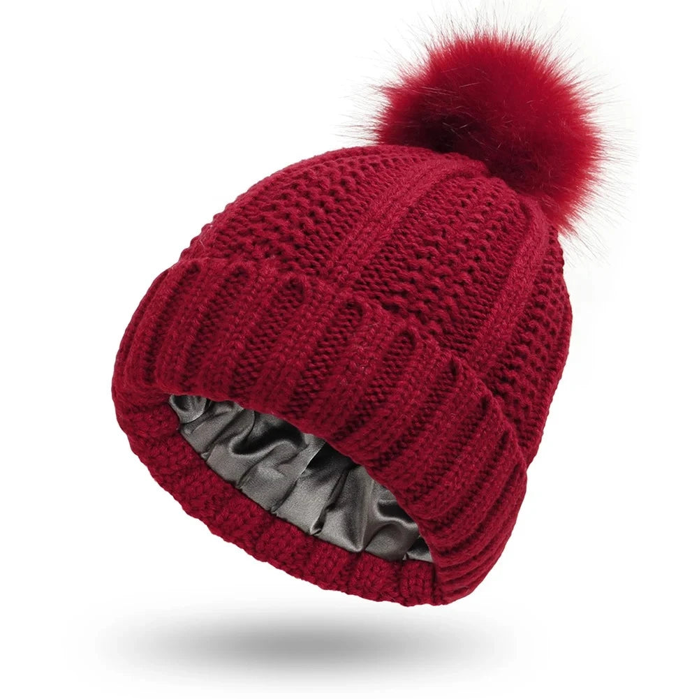 Red cable knit beanie with silk satin interior lining protects hair from frizz